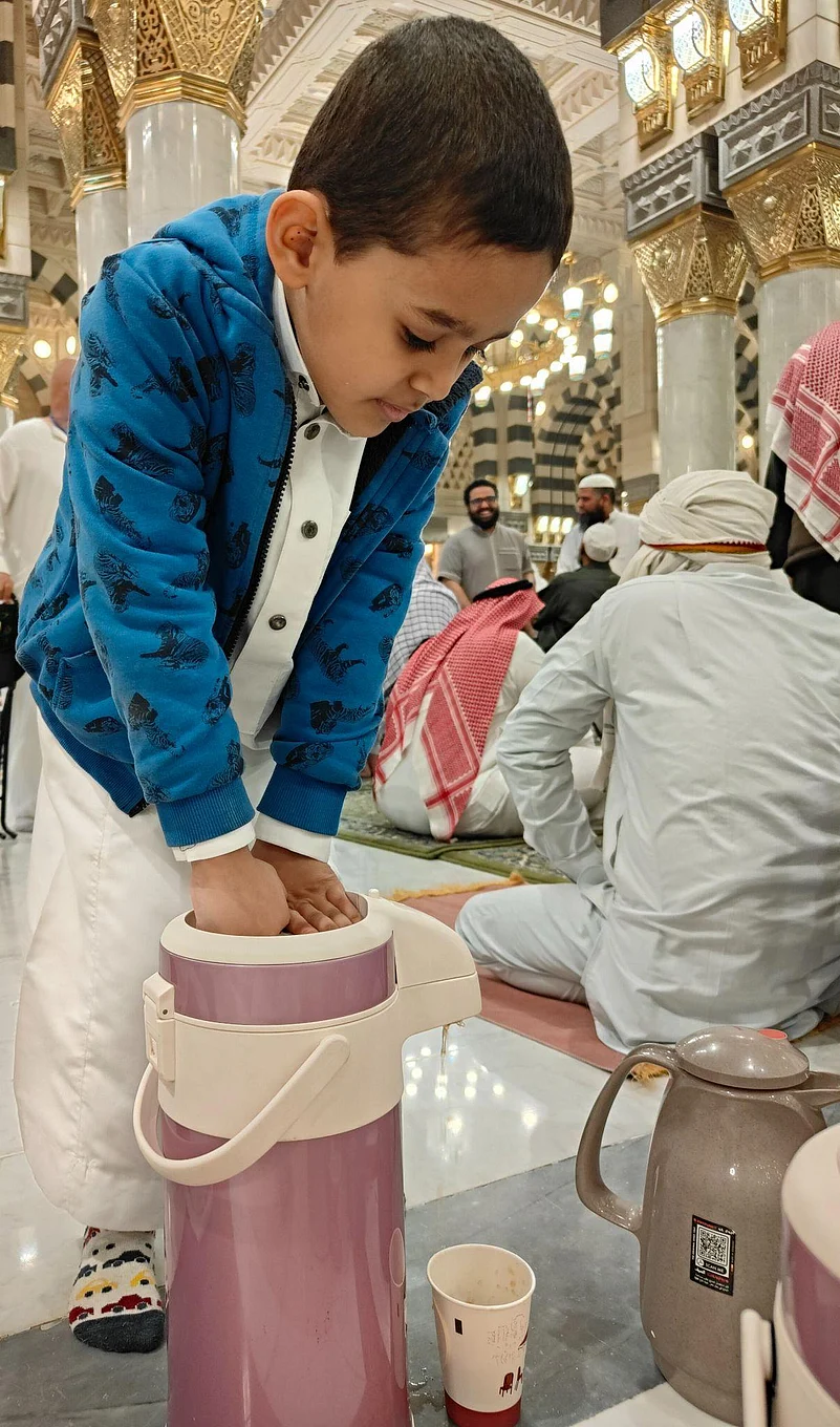 Yemeni Kid pours tea for worshippers after iftar