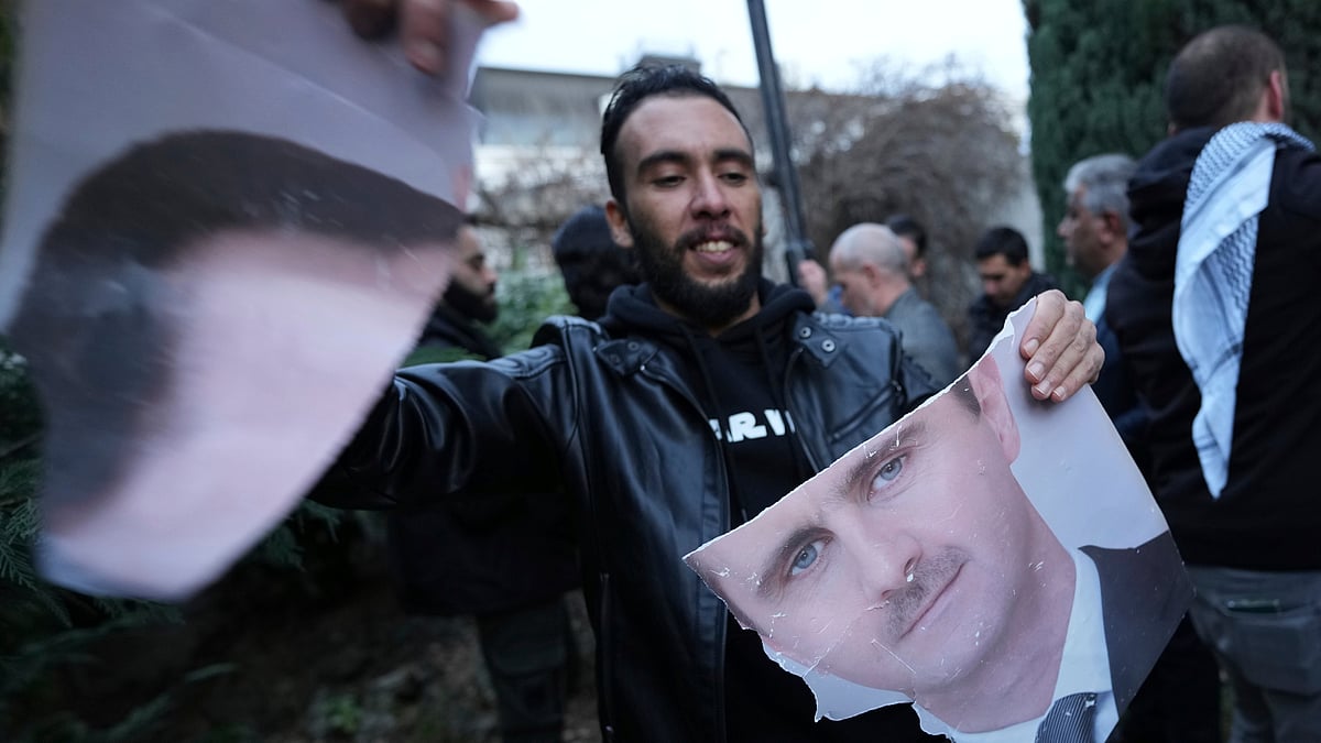 AP Photo/Darko Vojinovic : A man tears photo of Syrian President Bashar Assad in front of the Syrian embassy in Belgrade, Serbia, Sunday, Dec. 8, 2024. 