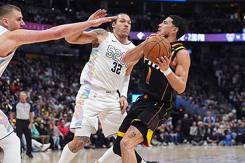 NBA 2024-25: Phoenix Suns guard Devin Booker, right, drives to the basket