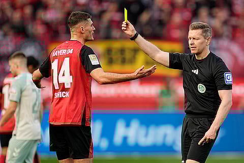 Bundesliga, Leverkusen and Werder Bremen: Referee Tobias Welz shows the yellow card to Leverkusen's Patrik Schick