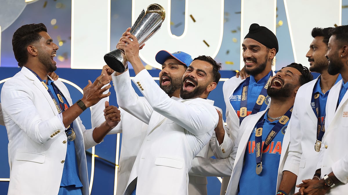 India's Virat Kohli and teammates celebrate with the winners trophy on the podium after defeating New Zealand in the final cricket match of the ICC Champions Trophy at Dubai International Cricket Stadium in Dubai. - AP Photo/Christopher Pike
