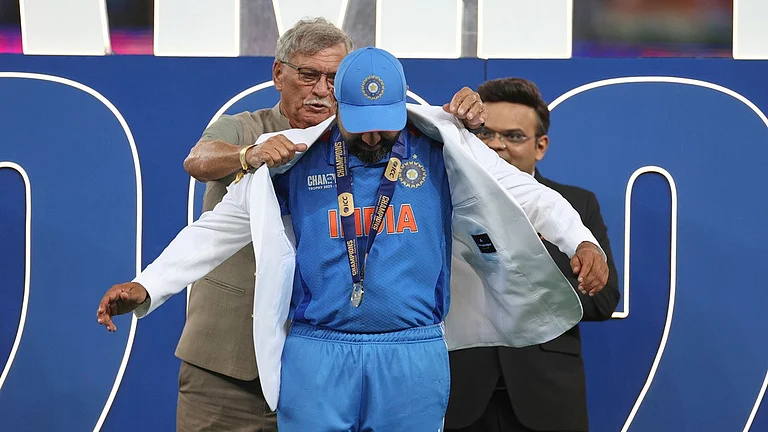 India's captain Rohit Sharma receives the white coat from BCCI President Roger Binny during the presentation ceremony of the ICC Champions Trophy after their win against New Zealand at Dubai International Cricket Stadium in Dubai, United Arab Emirates, Sunday, March 9, 2025. - AP/Christopher Pike