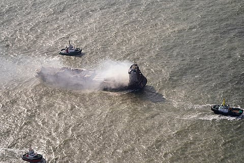Britain Ships Collide: Tug boats shadow the Solong container ship