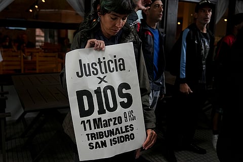 Argentina Maradona Trial: A fan of the late soccer star Diego Maradona holds a sign