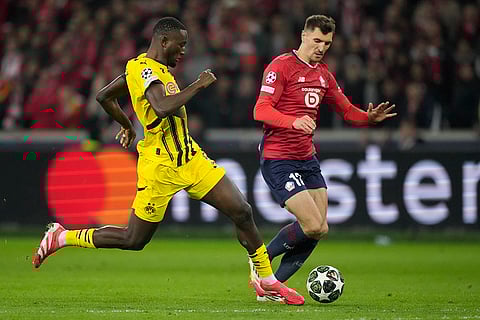 UCL 2024-25, Lille vs Dortmund: Dortmund's Serhiou Guirassy and Lille's Thomas Meunier fight for the ball 