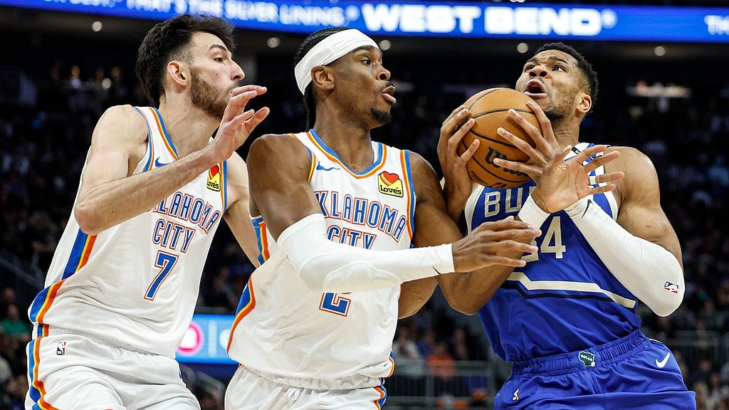 Photo: AP : Milwaukee Bucks' Giannis Antetokounmpo, right, drives against Oklahoma City Thunder's Shai Gilgeous-Alexander, center, and Chet Holmgren (7).