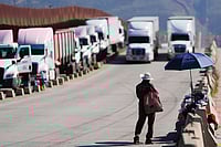| Photo: AP : The Impact: A man sells peanuts to truck drivers at the US border in Tijuana, Mexico, as tariffs against Mexico go into effect