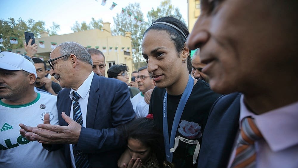 Algeria's boxer Imane Khelif smiles as she arrives home - | Photo: AP/Anis Belghoul