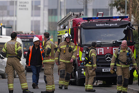 Firefighters wait around the North Hyde electrical substation