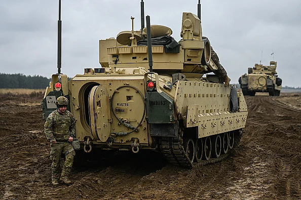 Soldier standing next to a tank