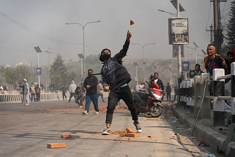 A pro-monarchy protestor pelts stones at police personnel during a protest in Kathmandu, Nepal, on March 28, 2025. - Photo by Rojan Shrestha/NurPhoto via Getty Images