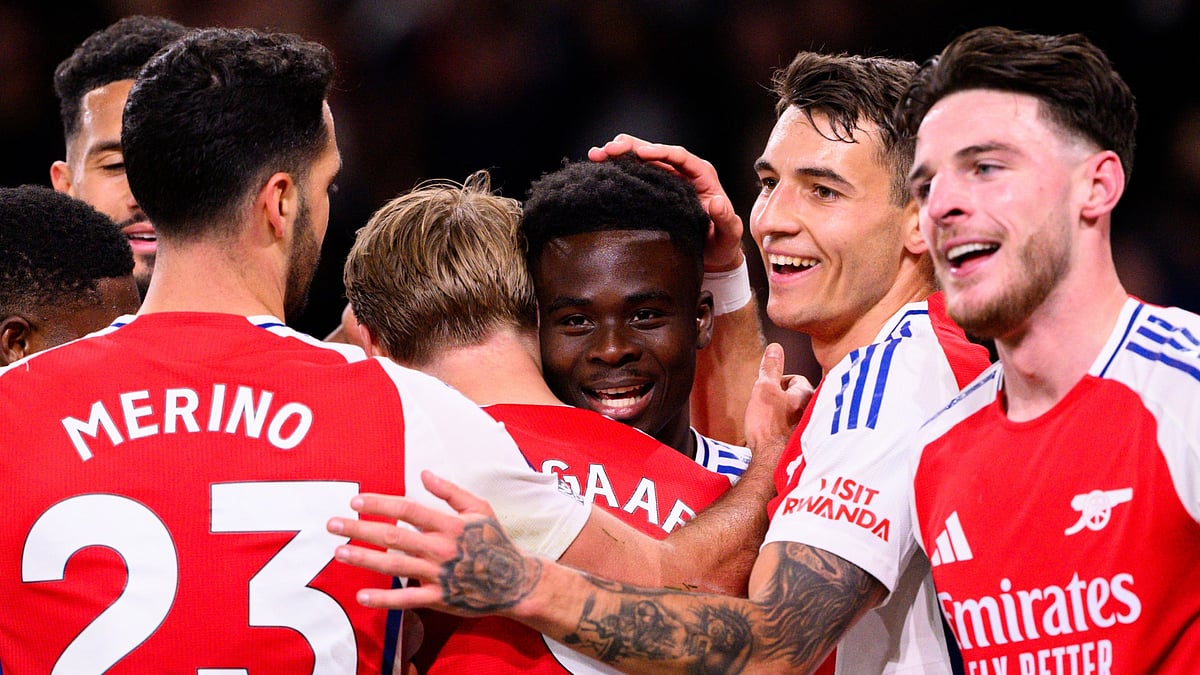 Arsenal players celebrate Saka's goal against Fulham.