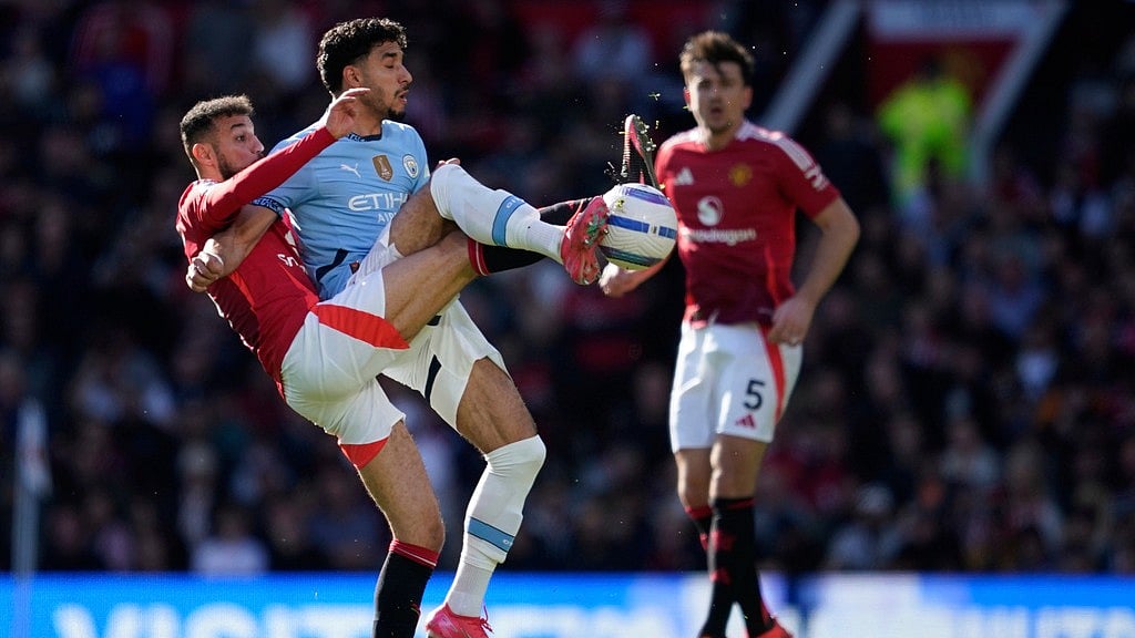 Photo: AP : Manchester United's Noussair Mazraoui, left, and Manchester City's Omar Marmoush fight for the ball during their English Premier League match.