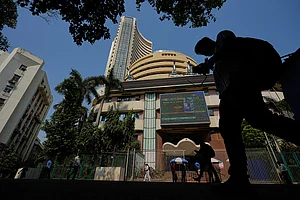 Photo: AP/Rafiq Maqbool : Office goers walk past the Bombay Stock Exchange building in Mumbai