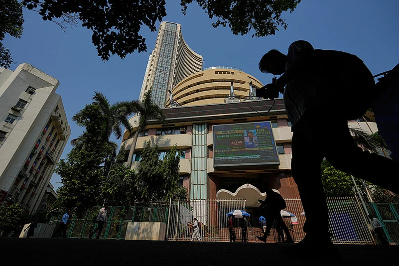 Office goers walk past the Bombay Stock Exchange building in Mumbai