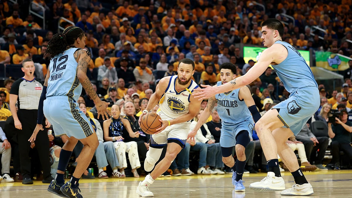 Stephen Curry #30 of the Golden State Warriors is guarded by Ja Morant #12, Scotty Pippen Jr. #1 and Zach Edey #14 of the Memphis Grizzlies in the first half of the NBA play-in tournament game at Chase Center on April 15, 2025 in San Francisco, California.