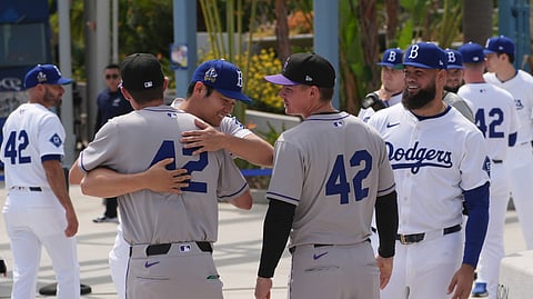 Los Angeles Dodgers' Shohei Ohtani, left, hugs members of the Colorado Rockies at Dodger Stadium during an event to commemorate Jackie Robinson Day on April 15, 2025, in Los Angeles.