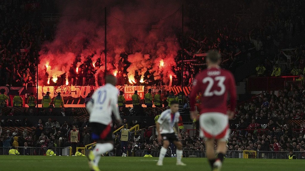 (AP Photo/Jon Super) : Lyon fans light flares during the Europa League quarter final second leg soccer match between Manchester United and Olympique Lyon in Manchester, Britain, Thursday, April 17, 2025.