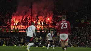 (AP Photo/Jon Super) : Lyon fans light flares during the Europa League quarter final second leg soccer match between Manchester United and Olympique Lyon in Manchester, Britain, Thursday, April 17, 2025.