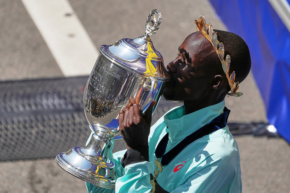 (AP Photo/Charles Krupa) : Boston Marathon winner John Korir, of Kenya, kisses the trophy while celebrating after the race, Monday, April 21, 2025, in Boston.