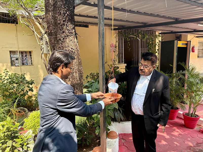 Shri Pranesh Kumar Pran filling a clay pot with water for birds