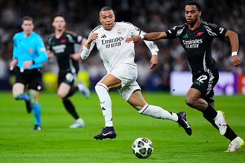 Real Madrid's Kylian Mbappe vies for the ball with Arsenal's Jurrien Timber, right, during their UEFA Champions League 2024-25 quarter-final second leg match at the Santiago Bernabeu Stadium in Madrid on April 16, 2025.