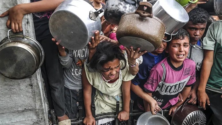 | Photo- Mahmoud İssa/Anadolu : Displaced Palestinian children crowd a food kitchen set up by aid organisations at the Jabalia refugee camp in northern Gaza on Thursday.