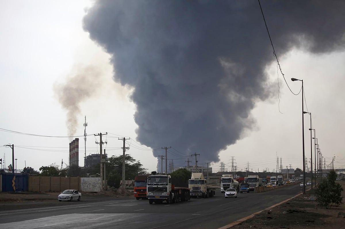 In this photo provided by Islamic Republic News Agency, IRNA, a black smoke rises in the sky as vehicles drive on the road after a massive explosion near the southern port city of Bandar Abbas, Iran, Saturday, April 26, 2025. - Mohammad Rasoul Moradi/IRNA via AP
