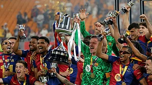 AP : Barcelona's Ronald Araujo, left, and Barcelona's goalkeeper Marc-Andre ter Stegen lift the trophy after winning the Spanish Copa del Rey final.