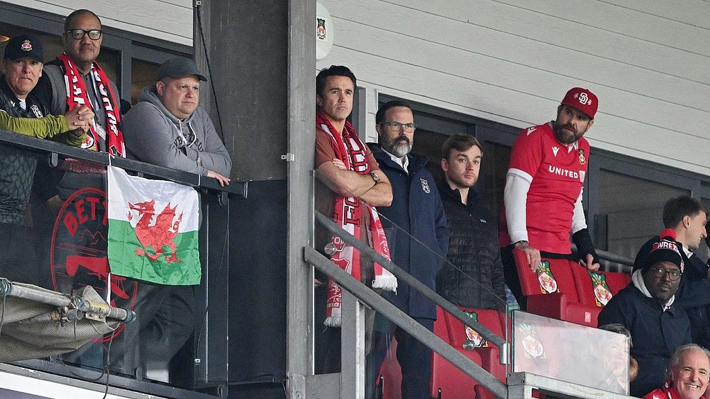 AP : Wrexham co-owner Rob McElhenney, center, watches from the stands during the English Football League One Soccer match between Wrexham and Bristol Rovers.
