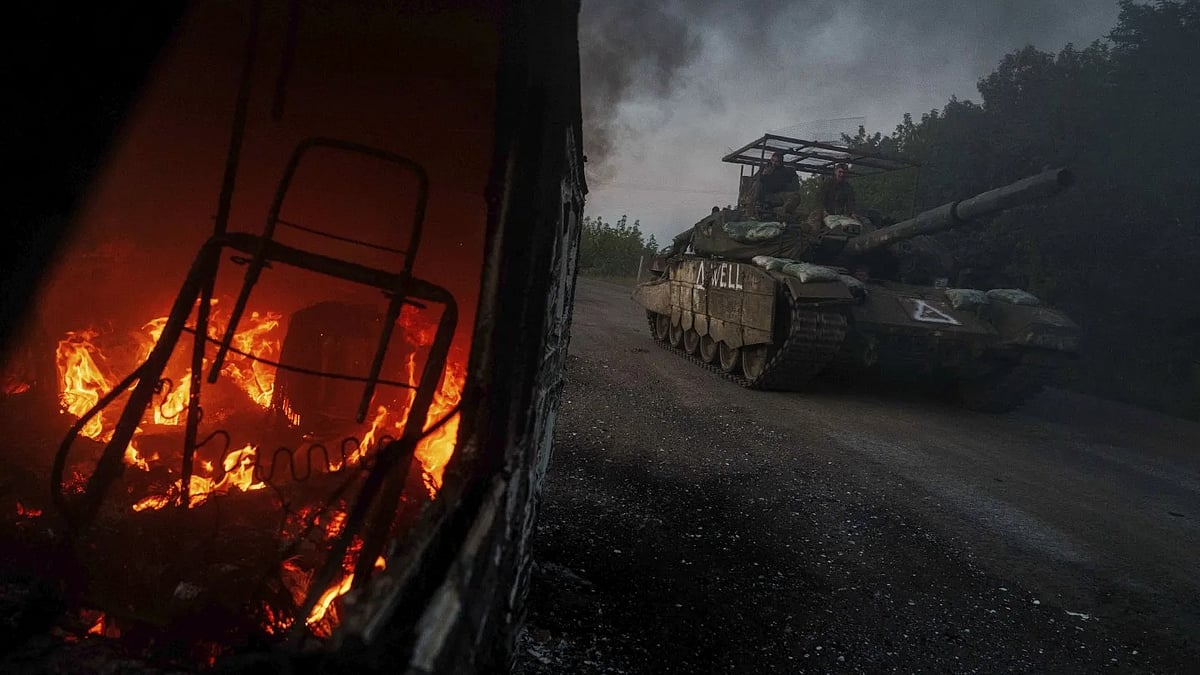 | AP/Evgeniy Maloletka/File : A Ukrainian tank passes by a burning car near the Russian-Ukrainian border in the Sumy region of Ukraine, Aug, 14, 2024.