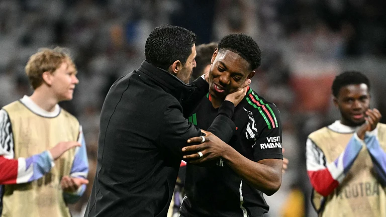 Myles Lewis-Skelly and Mikel Arteta embrace after Arsenal's win over Real Madrid - null