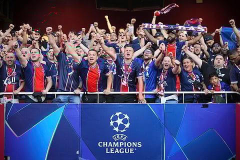 PSG fans cheer on the stands before the start of the Champions League semifinal first leg soccer match between Arsenal and Paris Saint-Germain at Arsenal Stadium in London.