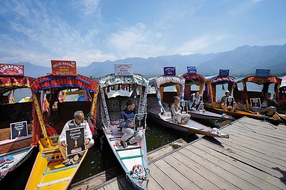 In Solidarity: Kashmiri boatmen hold placards to condemn the Pahalgam terror attack in Dal Lake, Srinagar - | Photo: AP