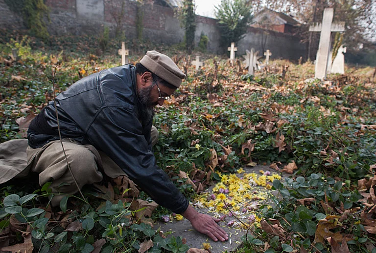 SRINAGAR, KASHMIR- NOVEMBER 22: A Kashmiri Muslim man scatters flowers on the grave as he pays homage to Robert Thorpe, on his 145th death anniversary at a Christian cemetery on November 22, 2013 Srinagar, the summer capital of Indian administered Kashmir, India. Robert Thorpes father Colonel E Thorpe married a Kashmiri woman in 1833. In 1865, a young Robert visited Kashmir and wrote extensively about the miserable plight of Kashmiri Muslims under the autocratic Dogra rule in publications like Friends of India. His posthumously-published book, 'Cashmere Misgovernment' is one of the "most authentic account of unpaid forced-labour Kashmir people were subjected to under the autocratic rule and other forms of mistreatment," according to one Kashmiri historian. Although deported from Kashmir by a rattled Dogra administration, Thorpe covertly returned to Kashmir but was found dead on a hill under mysterious conditions. - Yawar Nazir/Getty Images