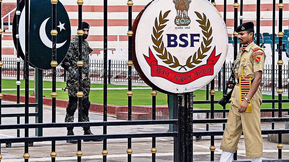 | Photo: PTI : Border Security Force soldiers and Pakistani Rangers stand guard at Attari-Wagah border