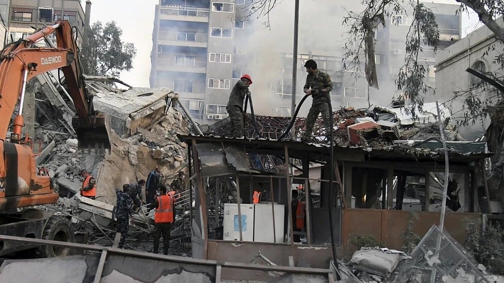 The workers clear the rubble at a destroyed building struck by Israeli jets in Damascus, Syria | Representational Image - AP