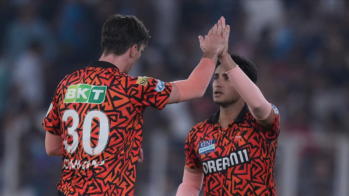 AP Photo/Siddharaj Solanki : Sunrisers Hyderabad's captain Pat Cummins, left, and Sunrisers Hyderabad's Abhishek Sharma celebrate the dismissal of Gujarat Titans' Jos Buttler during the Indian Premier League cricket match in Ahmedabad.