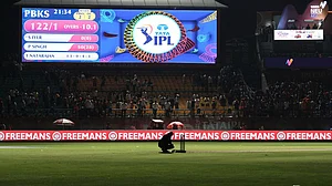 AP : A worker removes the equipment placed next to the stumps after the authorities asked to evacuate the stadium during the Indian Premier League match between Punjab Kings and Delhi Capitals in Dharamsala.
