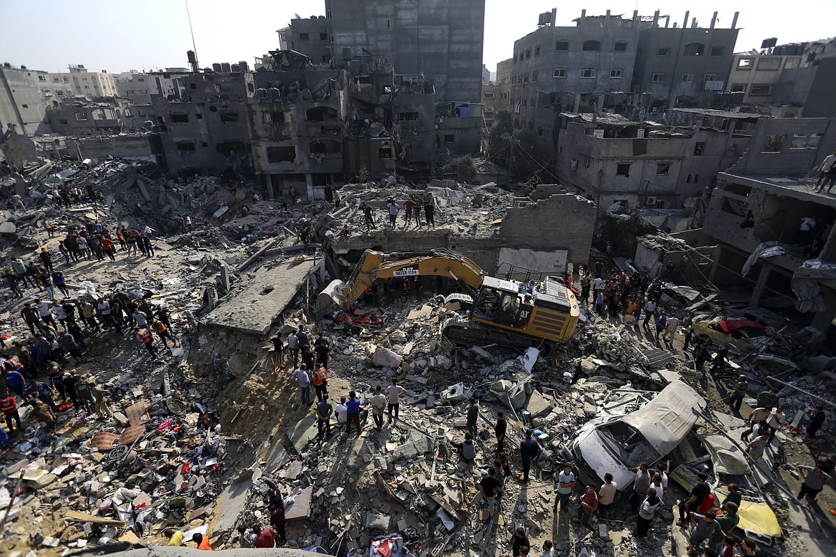 Palestinians looking for survivors under the rubbles after Israeli air strikes destroyed buildings - AP