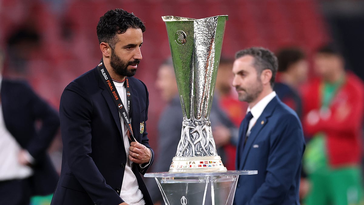 Ruben Amorim walks past the Europa League trophy - null