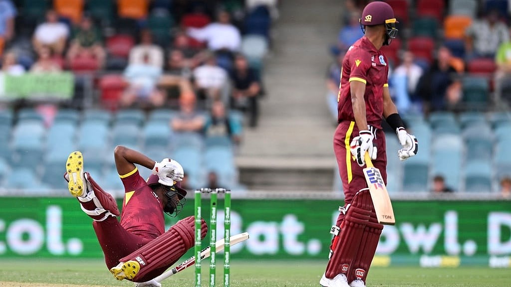 Photo: Lukas Coch/AAP via AP : Matthew Forde (left) falls as he is run out during the third one day international between Australia and the West Indies at the Manuka Oval in Canberra.