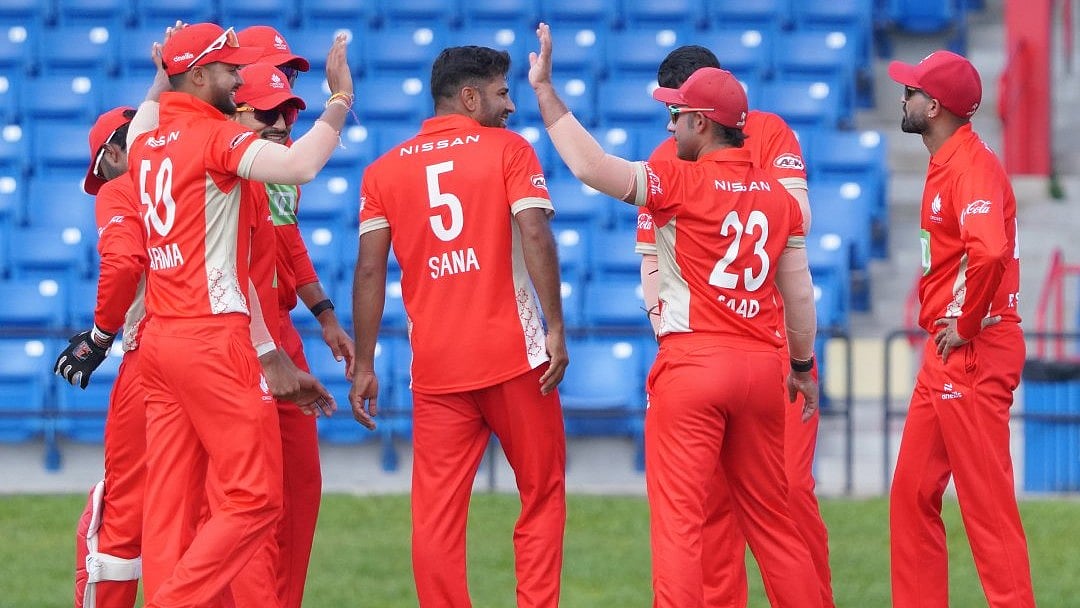 | Photo: X/canadiancricket : Canada national cricket team players celebrate after taking a wicket during the ICC Cricket World Cup League Two match 69 against Oman.