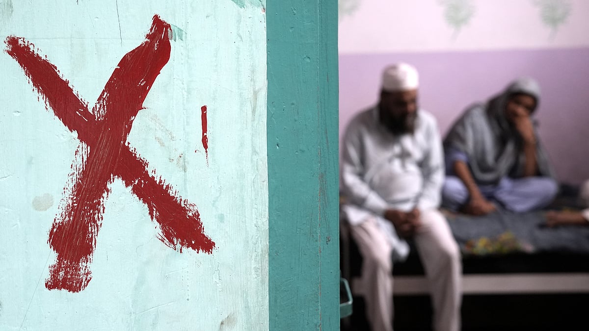 | Tribhuvan Tiwari | : Family sitting inside a house marked with a red cross in Khasra No 277, Batla House, Okhla.