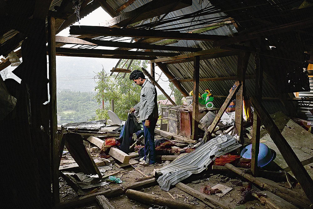 | Photo: Yasir Iqbal : Broken Dreams: A local searches for his belongings after shelling