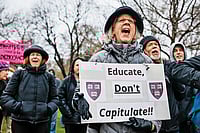 Photo: Getty Images : ‘Educate, Don’t Capitulate!’: A Cambridge protester urging Harvard to resist Trump’s influence on the institution