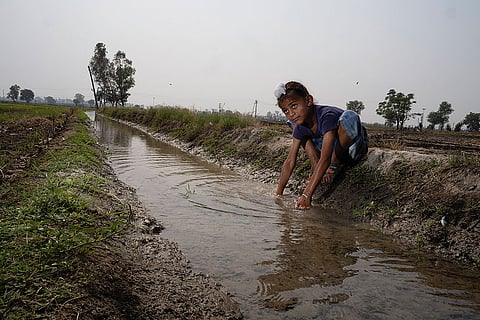 Uncertain Lives: A young boy plays in an irrigation canal at Daoke. In past conflicts, families have had to evacuate at short notice from this border village