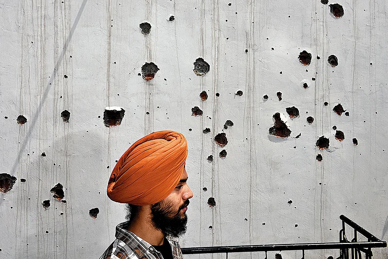 A family member of the deceased ex-serviceman, Amarjeet Singh, at their damaged house in Poonch