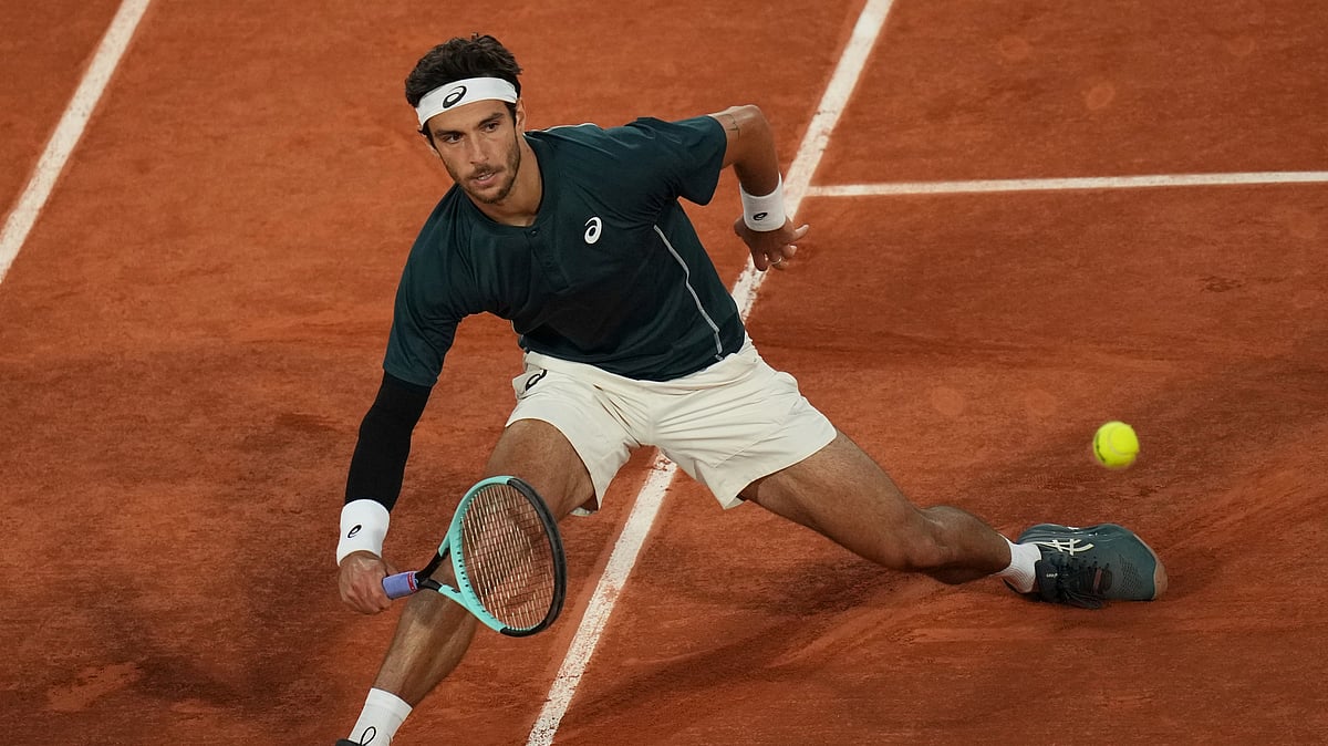AP Photo/Christophe Ena : Italy's Lorenzo Musetti returns the ball to Denmark's Holger Rune during their fourth round match of the French Tennis Open, at the Roland-Garros stadium, in Paris.