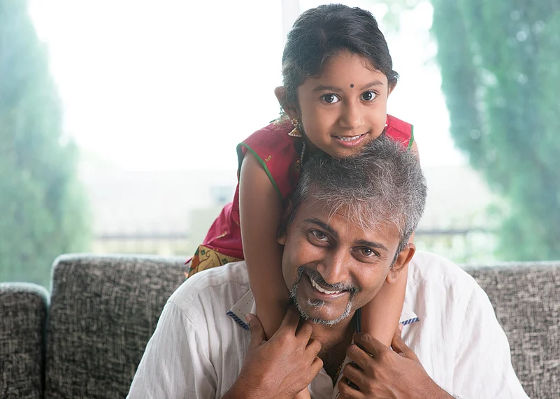 A Single father carries his daughter on his shoulder